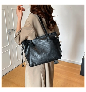 Close-up of the black tote bag with embossed kitty patterns and faux leather texture