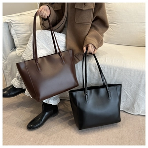 Comparison of brown and black leather tote bags shown with a neutral fall outfit