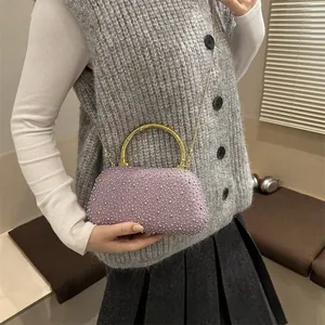 Dettaglio della borsa da sera con strass viola e manico in bambù dorato