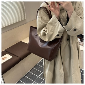 Dettaglio della borsa tote in pelle marrone con cuciture a ferro di cavallo e design