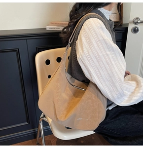 Detail view of large beige slouchy tote bag with vintage pleated leather texture and wide strap