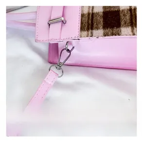 Detail van roze leren handtas met geruite stof en zilveren metalen sluiting