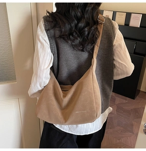 Back view of a model wearing a soft khaki slouchy tote bag with a suede texture finish