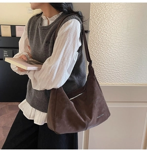 Close-up of retro large brown hobo bag showing zipper detail and matte suede texture