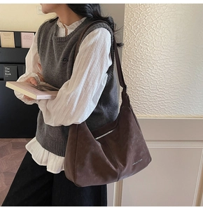 Close-up of a retro dark brown hobo bag with metal zipper and embossed side logo
