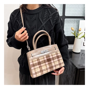 Detailopname van de retro handtas met kleurblokken en klassieke zilveren draaisluiting