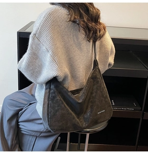 Macro shot of dark grey washed leather tote bag showing soft texture and logo detail