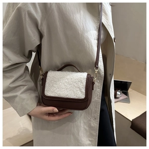 Detail view of mini crossbody bag featuring dark brown leather and white faux fur trim