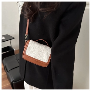 Detail of a vintage lamb wool and brown leather square bag shown on a model