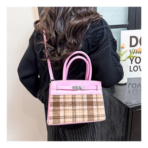 Detail van de roze en bruine geruite crossbodytas met verstelbare riem op de persoon