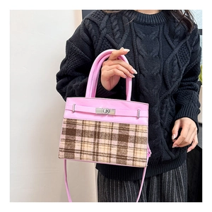 Detail van roze imitatieleer en geruite stof crossbody tas met zilveren draaisluiting