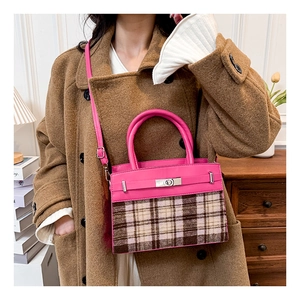 Detail van een roze en bruine geruite patchwork handtas met zilveren draaisluiting