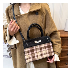 Detail van een color-block handtas in Kelly-stijl met ruitjesstof en zilveren slot