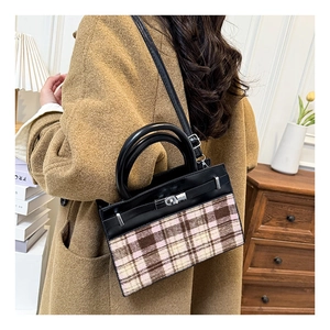 Detail van vintage patchwork handtas met geruite stof en metalen draaisluiting