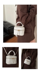 Detail of white crocodile pattern mini box bag with chain strap and top handle