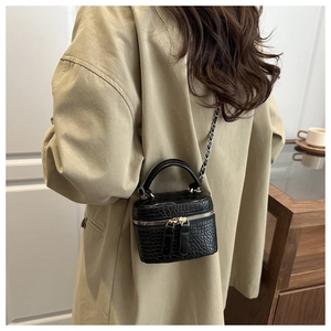 Detail of black croc-embossed mini box bag with chain strap and gold-tone hardware