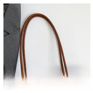 Detail of premium woven tote bag featuring reinforced brown leather round handles and stitching