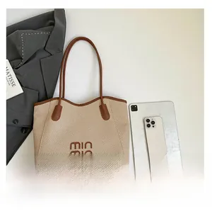 Detail of woven tote bag featuring brown leather trim and a spacious interior for commuting
