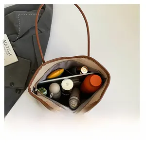 Interior view of large beige woven tote bag showing spacious capacity and brown straps