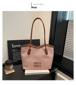 Pink tote bag detail with brown leather straps and stylish text on a cafe setting
