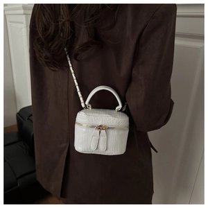 Detail of off-white crocodile embossed mini box bag with gold zipper and chain strap