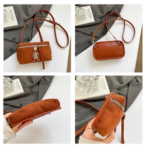 Detailansicht der braunen Wildledertasche mit Roboterkette und silbernem Reißverschluss