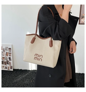 Chic beige woven tote bag with brown trim and min min logo shown on model