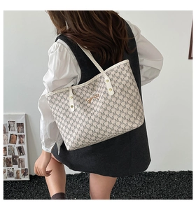 Vue latérale du sac cabas crème avec imprimé monogramme M et fermoir nœud doré
