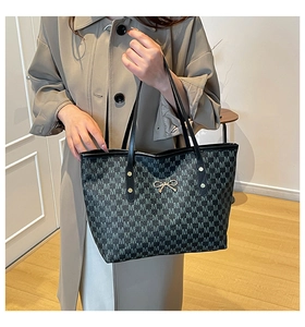 Détail du grand sac cabas avec monogramme de lettres M et pendentif nœud doré
