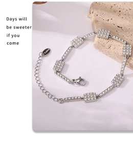 Detailed close-up of a silver stainless steel bracelet featuring square zircon stones and clasp