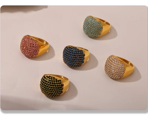 Detail of five gold-plated rings with colorful square-cut zircons in various vibrant tones