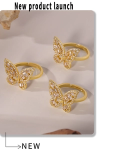 Makroaufnahme von drei goldenen Schmetterlingsringen mit Zirkonia-Pavé und Hohlflügeln