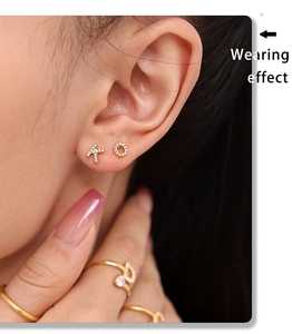 Detail of gold letter earrings and ring set with cubic zirconia on model
