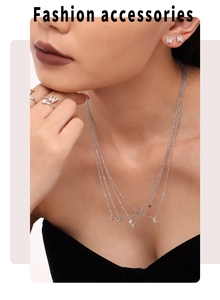 Silver letter necklace, earrings, and ring set with zircons shown on a female model
