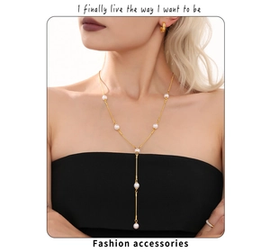 Détails du set collier Y et perles dorées porté sur une tenue noire chic