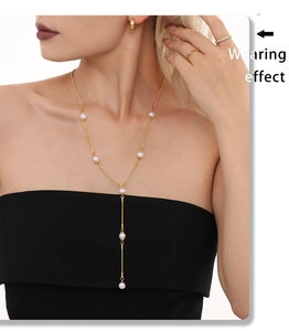 Mannequin portant un collier en perles en Y doré avec boucles et bagues assorties