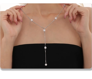 Gros plan d'un collier lasso en Y argenté avec cinq perles rondes sur un mannequin