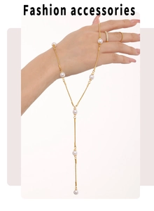 Détail du collier de perles en Y doré et bagues assorties sur un mannequin femme