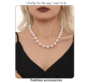 Vue détaillée du collier de perles blanches élégant avec perles dorées sur mannequin