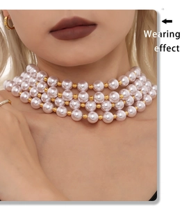 Détail d'un choker à quatre rangs de perles de nacre blanches avec billes dorées