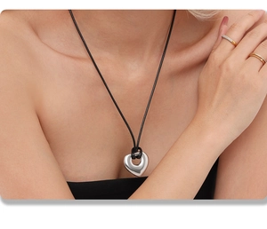 Détail d'un pendentif cœur poli sur un collier réglable en cordon noir