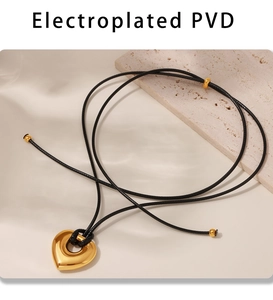 Détail du pendentif cœur doré PVD avec cordon noir réglable sur un support en pierre