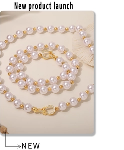 Détail du collier de perles avec fermoir fer à cheval doré et cristaux scintillants