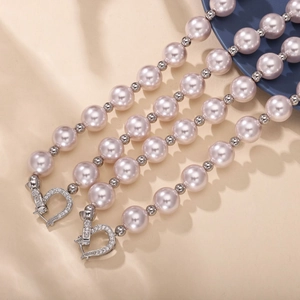Gros plan d'un collier de perles roses avec fermoir en forme de cœur pavé
