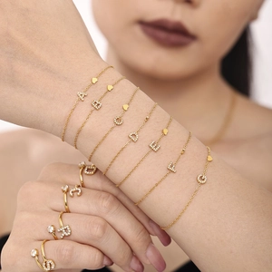 Golden titanium steel jewelry set with zircon letter charms and heart pendant detail