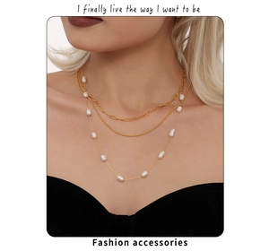 Detailweergave van de drielaagse gouden ketting met barokparels op een model