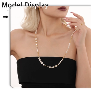 Détail d'un long collier en perles d'eau douce avec perles dorées sur mannequin