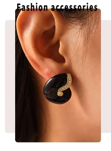 Close-up of vintage gold plated enamel earrings with white zircon on model ear