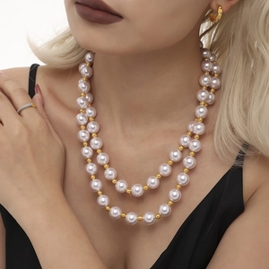Collier de perles à double rangée avec perles dorées porté par un mannequin élégant