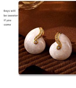 Detail of vintage teardrop earrings with marble texture and gold plated edges